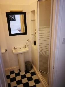 布莱克浦Delamere Hotel的一间带水槽、淋浴和镜子的浴室