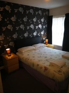 布莱克浦Delamere Hotel的一间卧室配有一张带花卉壁纸的床