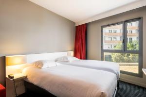 里昂奥特里亚商务与休闲公寓式酒店的酒店客房设有床和窗户。