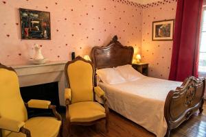 瓦尔莱班Hôtel Restaurant Les Touristes的一间卧室配有一张床和两把椅子