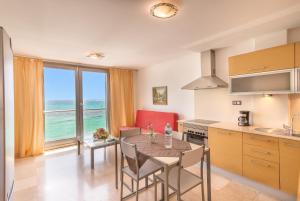 科拉雷侯Hotel LIVVO Corralejo Beach的享有海景,设有带桌椅的厨房