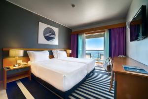 塞辛布拉SANA塞新布拉酒店的酒店客房设有一张大床和一台电视。