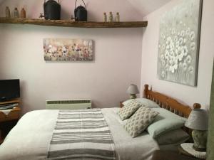 科比Moat Cottage Barns的卧室配有一张床,墙上挂有绘画作品