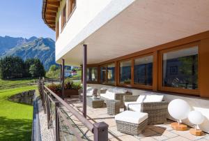 米特尔贝格莱特纳酒店的一个带沙发和椅子的庭院,阳台享有山景