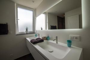 HerzeleQ Studio的白色的浴室设有水槽和镜子