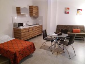 阿尔卡拉拉雷亚尔拉韦德格拉纳达公寓的一间卧室配有一张床铺和一张桌子,还设有一间厨房