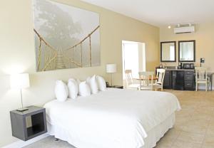 塔瓦雷斯Key West Resort - Lake Dora的卧室配有白色床,墙上挂有桥画