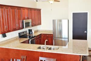 塔瓦雷斯Key West Resort - Lake Dora的厨房配有木制橱柜和不锈钢冰箱。