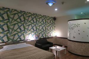 Miyaki嘉年华情趣酒店的配有一张床和一把椅子的酒店客房