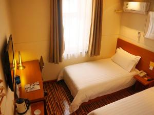 大同金广快捷酒店大同南环路店的酒店客房设有两张床和窗户。