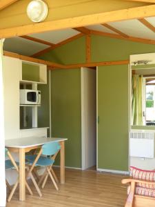 库迪列罗Camping L´Amuravela的厨房设有绿色的墙壁和桌椅