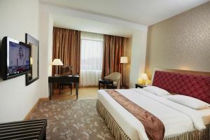 巴东巴东洛基广场酒店的酒店客房设有一张大床和一张书桌。