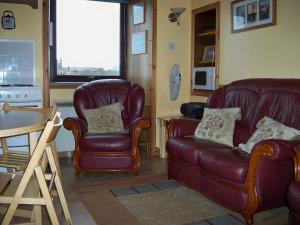 SandwickRoadside Cottage的客厅配有沙发、椅子和桌子
