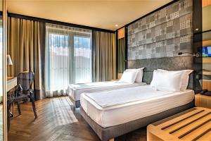 索非亚Eurostars Sofia City的酒店客房配有两张床和一张书桌