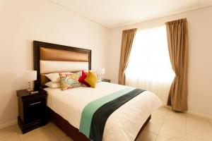 哈博罗内Apartments @ 125的一间卧室设有一张大床和一个窗户。