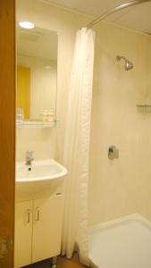 香港 铜锣湾宾馆（波斯富街）的浴室配有水槽和带浴帘的淋浴