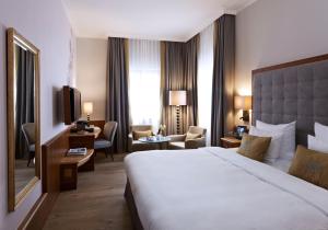 慕尼黑普拉茨尔酒店 - 高级的酒店客房设有一张大床和一台电视。