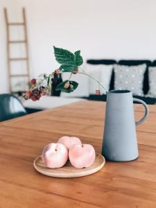 巴塞尔巴塞尔奥威活力城市公寓的花瓶旁的盘子上三个粉红色的甜甜圈