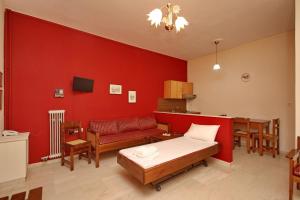 古厄庇道鲁斯Hotel Marialena的一间设有床铺和红色墙壁的房间