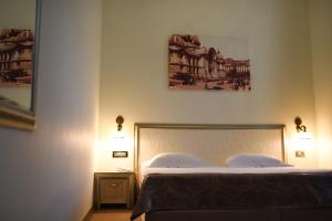 布加勒斯特格利韦塔欧洲酒店的一间卧室配有一张带两盏灯的床。