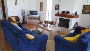西尔维拉Villa da Praia Azul的客厅配有2把蓝色椅子和桌子