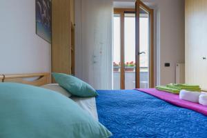 阿科B&B agli Ulivi的一间卧室配有一张带蓝色床单的床和一扇窗户。
