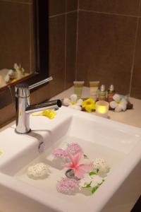 格兰贝伊Ocean Villas Hotel的浴室水槽内装有鲜花的水龙头