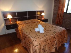 门多萨Cabañas El Challao的酒店客房的床铺上配有白色毛巾