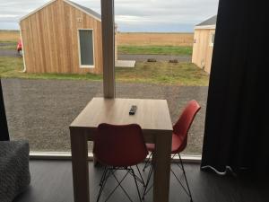 Eyvindarhólar迎宾度假屋的窗前的一张桌子和两把椅子