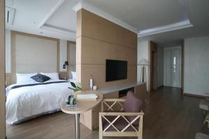 丽水市丽水贝尼克酒店的一间卧室配有一张床、一张书桌和一台电视。