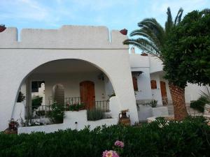 托雷斯佩基亚鲁杰里Villa Maria的一座白色的房子,有拱门和棕榈树