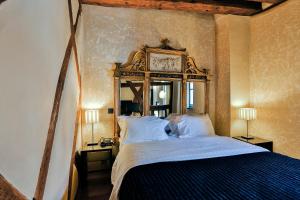 利克维Le B. Suites, Chambres & Restaurant的卧室配有一张挂在墙上的带时钟的床