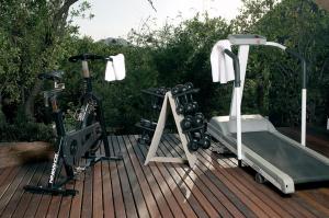 马迪克韦狩猎保护区Etali Safari Lodge的木甲板上的跑步机和自行车