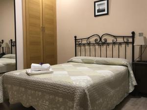 马德里埃尔皮拉尔旅馆的一间卧室配有一张床,上面有两条毛巾