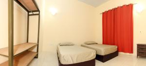 阿克拉Connect Africa Apartments的一间卧室设有两张床和红色窗帘