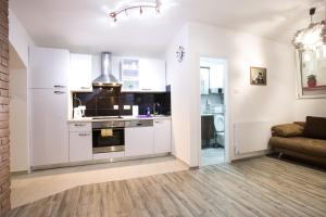 萨格勒布Apartman Vita的一间厨房,内设白色橱柜和沙发