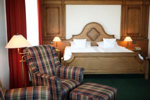 韦尔梅菲尔德- 伍德泰格斯酒店的一间卧室配有一张床、一把椅子和一张床