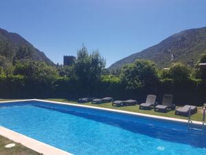 里贝拉德卡多斯拉里布拉酒店的一个带椅子的游泳池,背景是山脉