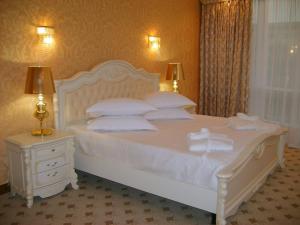日托米尔盖伊基酒店的卧室配有白色的床铺和白色的枕头