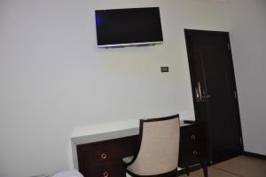 亚的斯亚贝巴北阿迪斯酒店的一间设有两把椅子和一台墙上的电视的房间