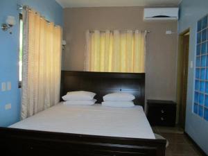 Libertad乌考海滩度假酒店的一间卧室配有带白色床单和枕头的床。