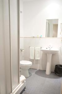 卡塞雷斯AHC酒店的白色的浴室设有卫生间和水槽。