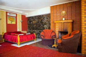 文尼察Ideal Hotel的一间卧室配有一张床和椅子,以及一个壁炉