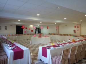 卡塞雷斯AHC酒店的宴会厅配有白色桌椅和红色气球