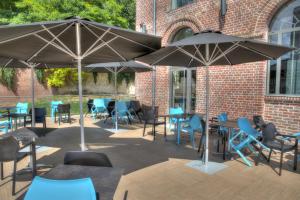 Méru特布莱特里酒店的一个带桌椅和遮阳伞的庭院