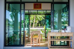 甲米镇瓦纳罗姆公寓式酒店的餐厅设有玻璃门和桌椅