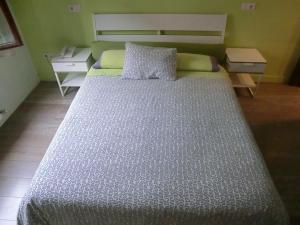 格尔尼卡阿克拉瑞旅馆的一张大床,位于一个小房间里,配有一张小床和一张四柱床