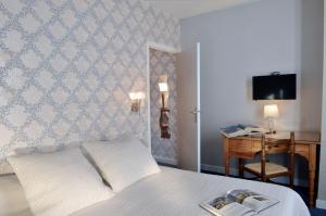 图尔杜马诺尔酒店的一间卧室配有一张床和一张书桌及电视