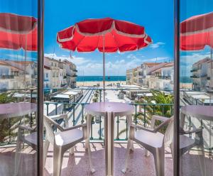 纳扎雷Solar dos Carvalhos - Apartamentos de Turismo的庭院配有桌椅和遮阳伞。