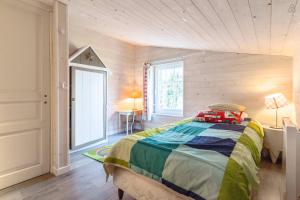 盖朗德La Maison Bizienne Guérande的卧室配有一张床铺,位于带木墙的房间内